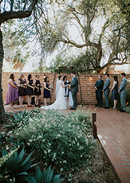 Photo of a bride and groom kissing with the desert in the background